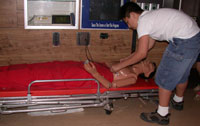 A child in the ambulance examines the dummy patient and equipment.